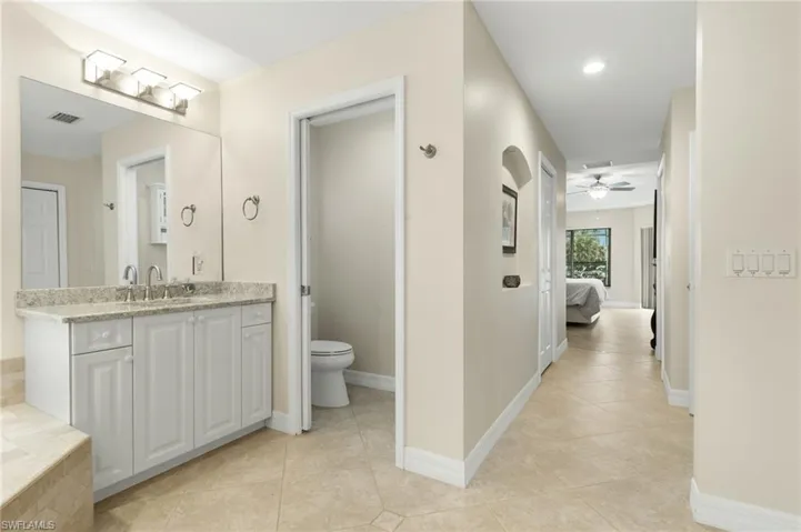 Full bath featuring light tile patterned flooring, vanity, connected bathroom, ceiling fan, and recessed lighting