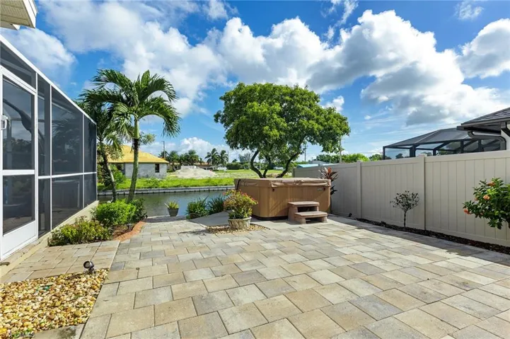 View of patio / terrace featuring a hot tub, a lanai