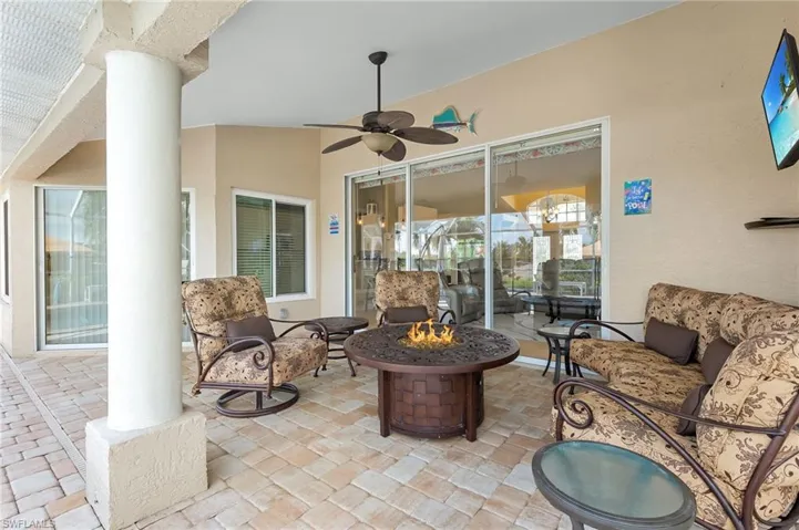 View of patio featuring an outdoor living space with a fire pit and ceiling fan
