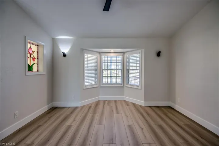 Empty room featuring baseboards and light wood-style flooring