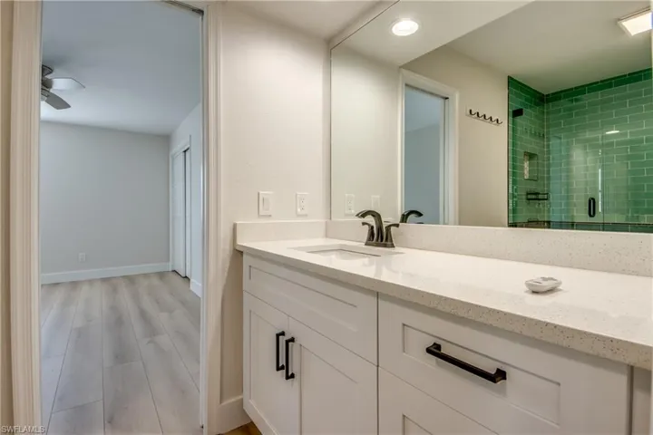 Full bath featuring vanity, light wood finished floors, a stall shower, and recessed lighting