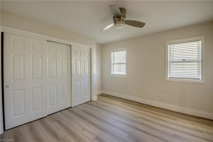 Unfurnished bedroom featuring a closet, ceiling fan, and light wood-style floors