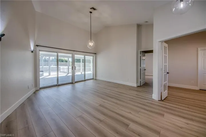 Unfurnished living room featuring high vaulted ceiling and light wood finished floors