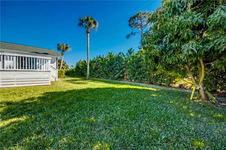 View of green lawn featuring a deck