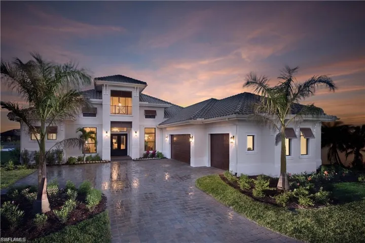View of front of home with a garage, decorative driveway, stucco siding, french doors, and a tiled roof