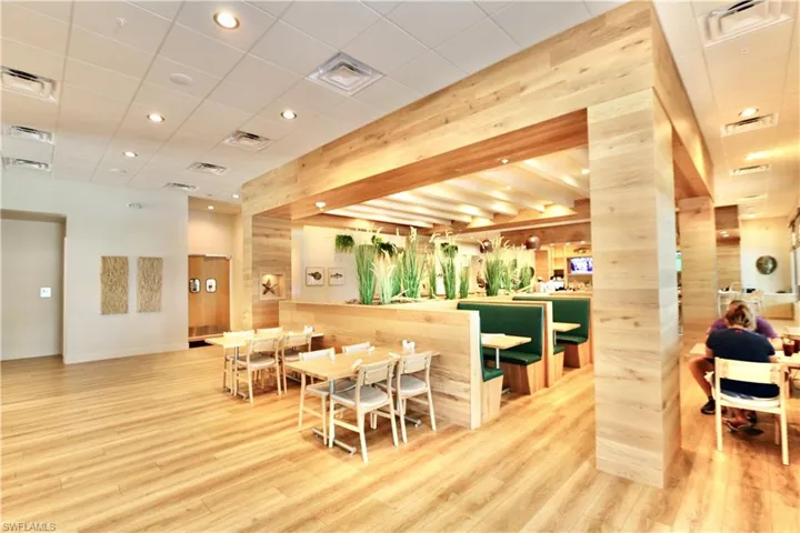 Dining area with light wood-type flooring, recessed lighting, baseboards, and wood walls