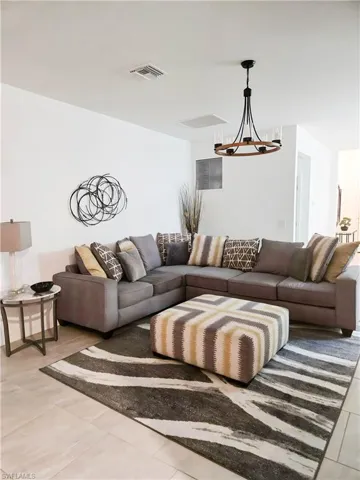 Living area featuring a chandelier and light tile patterned floors