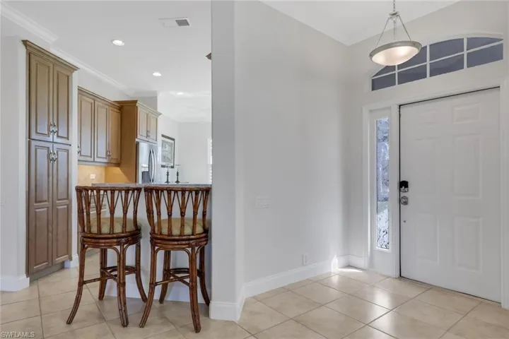 Entryway featuring ornamental molding, light tile patterned floors, and recessed lighting