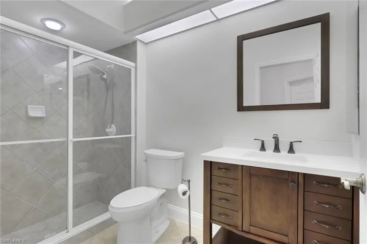Full bath with vanity, a stall shower, and light tile patterned floors
