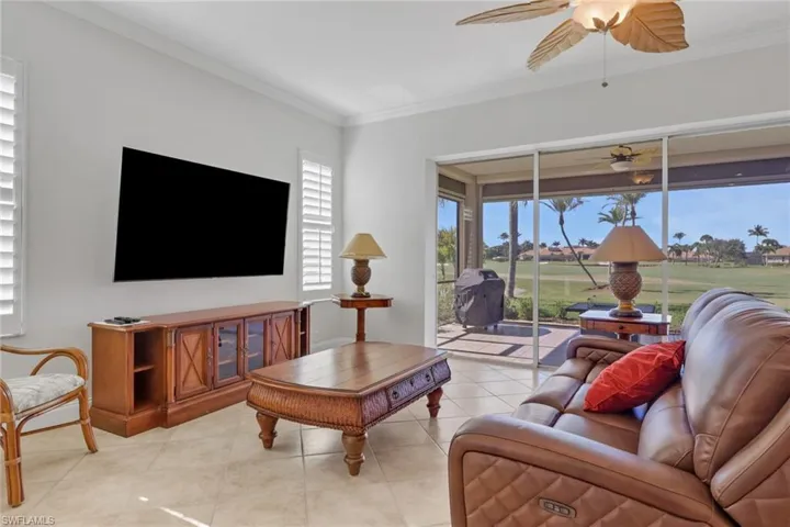 Living area with ornamental molding, a ceiling fan, and tile patterned floors