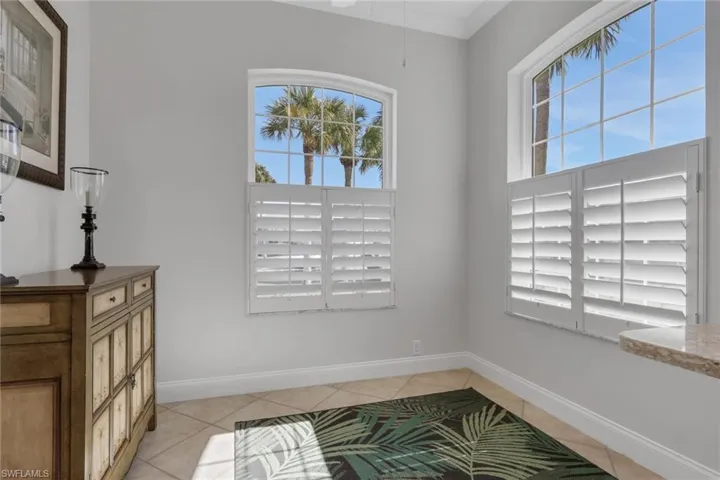 Foyer entrance with light tile patterned floors and ornamental molding