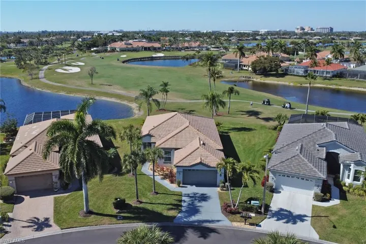 Aerial perspective of suburban area with a golf course and a large body of water