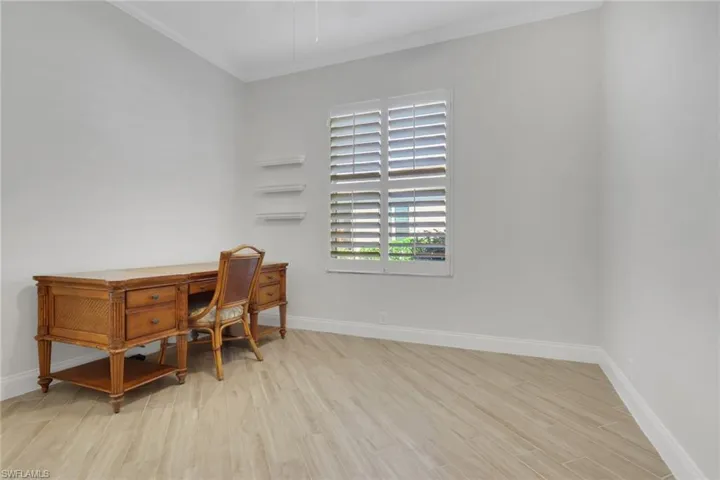 Office featuring light wood-type flooring and crown molding