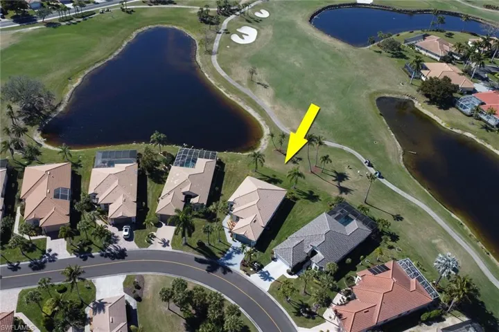 Aerial view of property's location featuring nearby suburban area, a nearby body of water, and a golf course