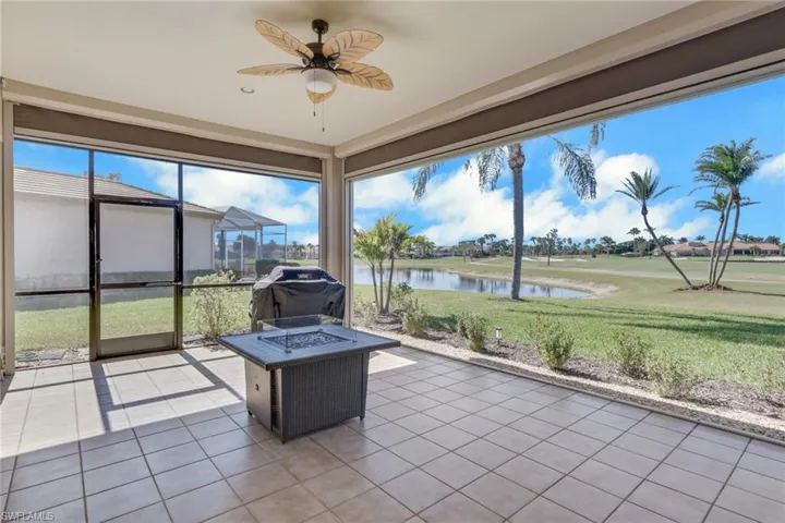 Unfurnished sunroom with a fire pit, a water view, and ceiling fan