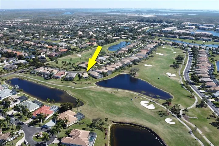 Aerial view of property and surrounding area featuring nearby suburban area and a local golf course