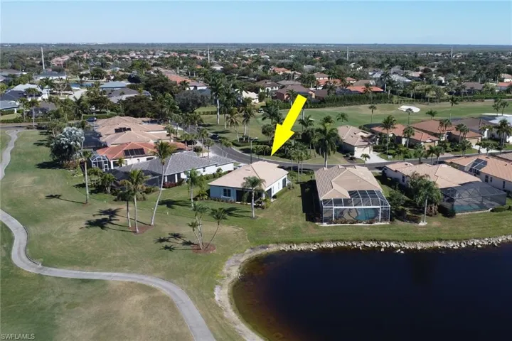 Aerial view of residential area with a golf club and a nearby body of water