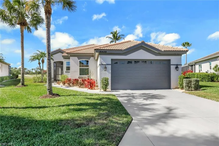 Mediterranean / spanish-style house featuring stucco siding, a garage, a front lawn, a tile roof, and concrete driveway