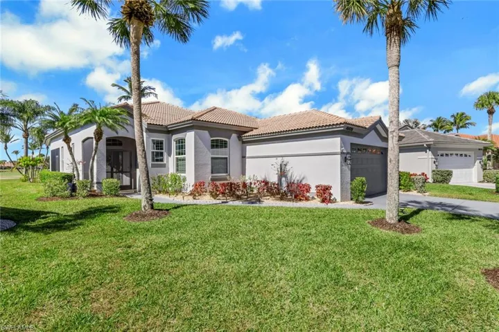 Mediterranean / spanish-style home with stucco siding, a front yard, a tiled roof, a garage, and driveway