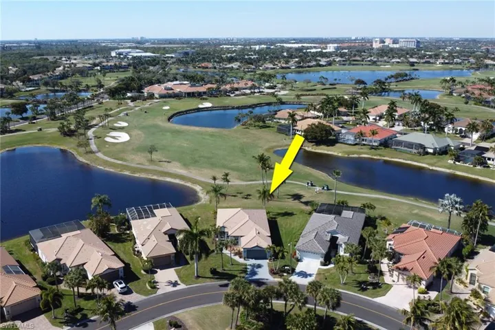 Aerial view of property's location featuring a local golf course and nearby suburban area
