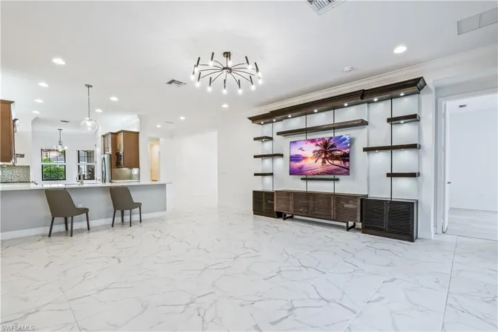 Living room with crown molding and a notable chandelier