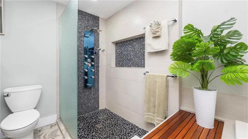 Bathroom featuring toilet and a stall shower