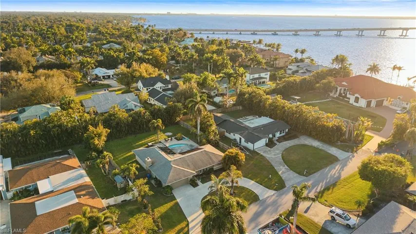 Aerial perspective of suburban area featuring a large body of water and a notable bridge