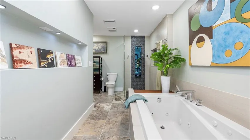 Full bath with a stall shower, a whirlpool tub, and recessed lighting