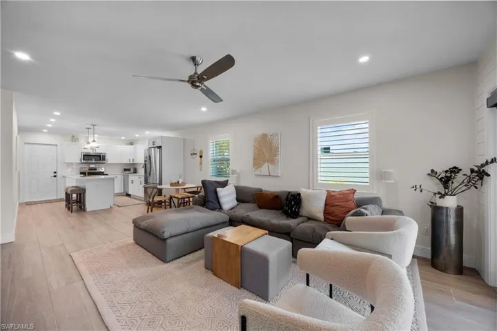 Living room with ceiling fan and light wood-type flooring