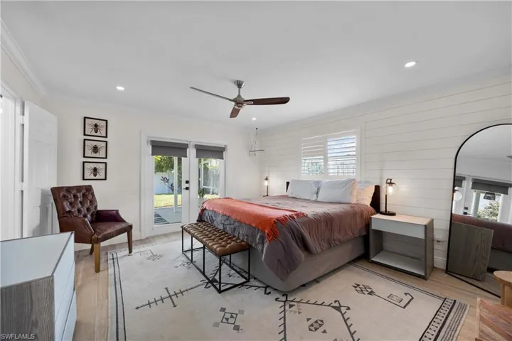 Bedroom featuring ceiling fan, multiple windows, and light hardwood / wood-style flooring