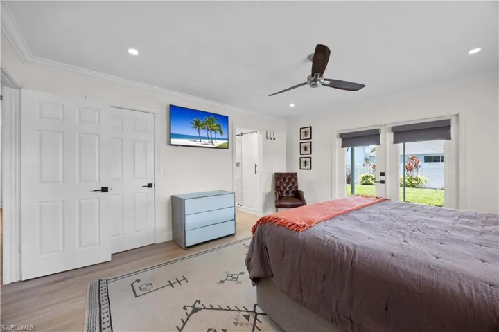 Bedroom featuring light wood-type flooring, ornamental molding, access to outside, and ceiling fan