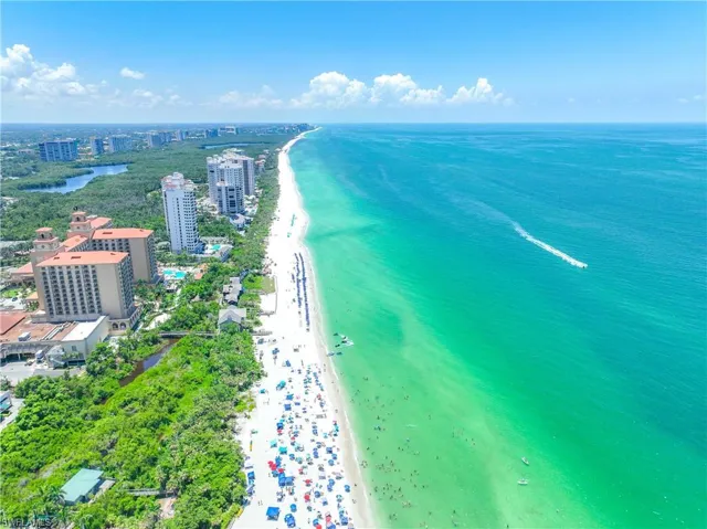 Birds eye view of property with a view of the beach and a water view