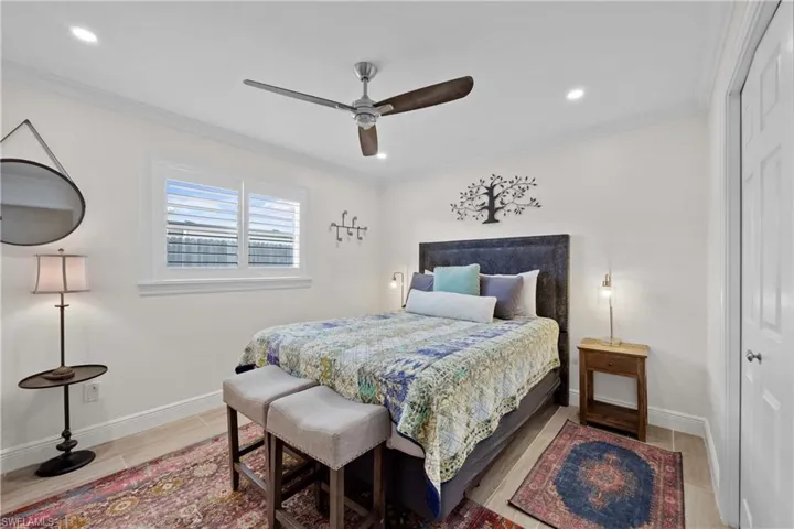 Bedroom with crown molding, hardwood / wood-style flooring, and ceiling fan