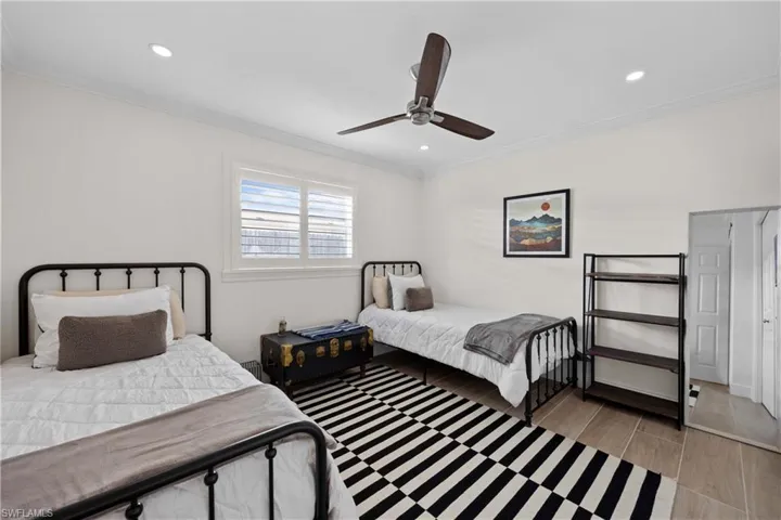 Bedroom with crown molding, ceiling fan, and hardwood / wood-style floors