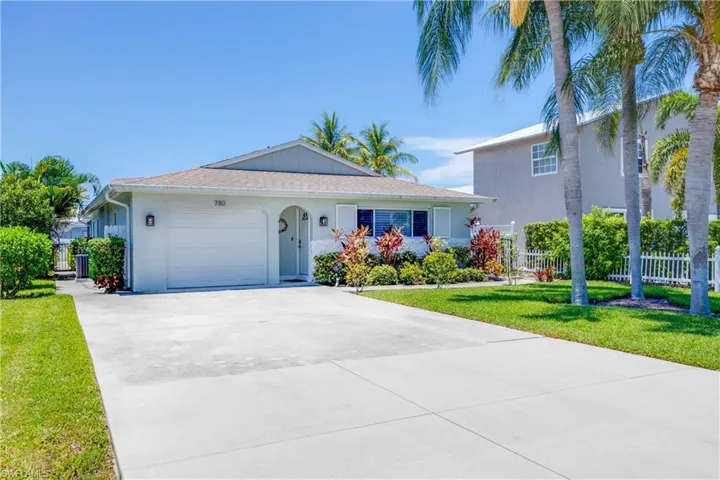 View of front of house featuring a garage and a front yard with gates on left and right