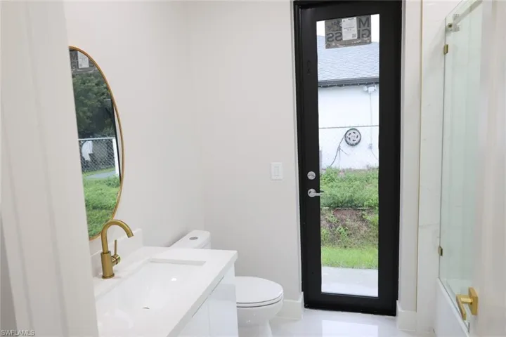 Bathroom featuring vanity and shower / bath combination with glass door