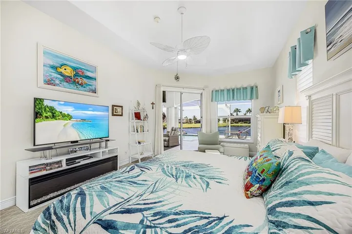 Tray ceiling with integrated ceiling fan, glass sliding doors, and neutral wall tones