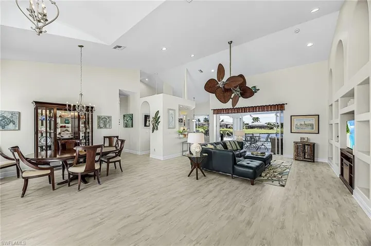 Vaulted ceilings, LVP flooring, recessed lighting, expansive multi-tiered built-in shelving, and large-scale sliding glass doors