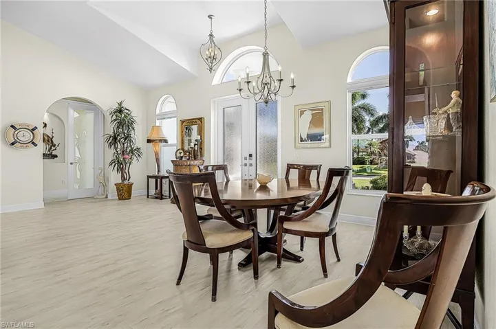 Vaulted ceilings, arched architectural details, full-length arched windows, and multi-light chandeliers