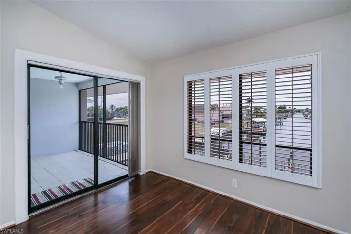 Unfurnished room with dark wood finished floors, a textured ceiling, and vaulted ceiling