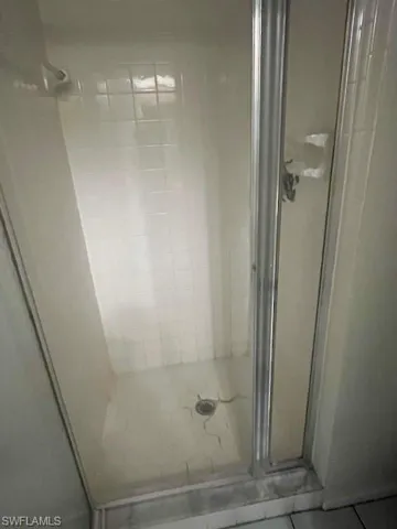 Full bath with a stall shower and tile patterned flooring