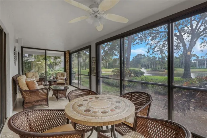Sunroom / solarium featuring ceiling fan, a water view, and outdoor dining space
