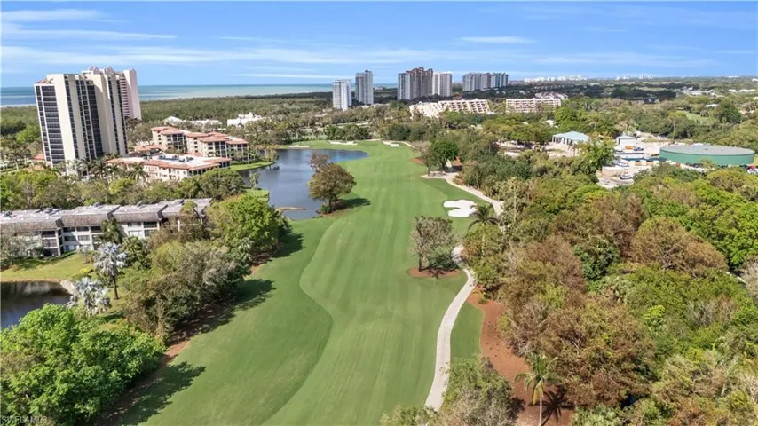 Aerial view of property's location with a golf course and a large body of water