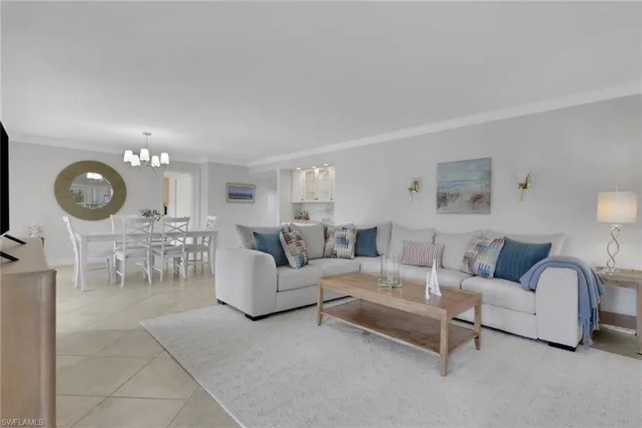 Living area featuring crown molding, light tile patterned flooring, and a chandelier