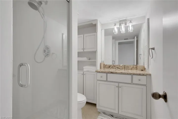 Bathroom with vanity, a shower stall, and light tile patterned floors