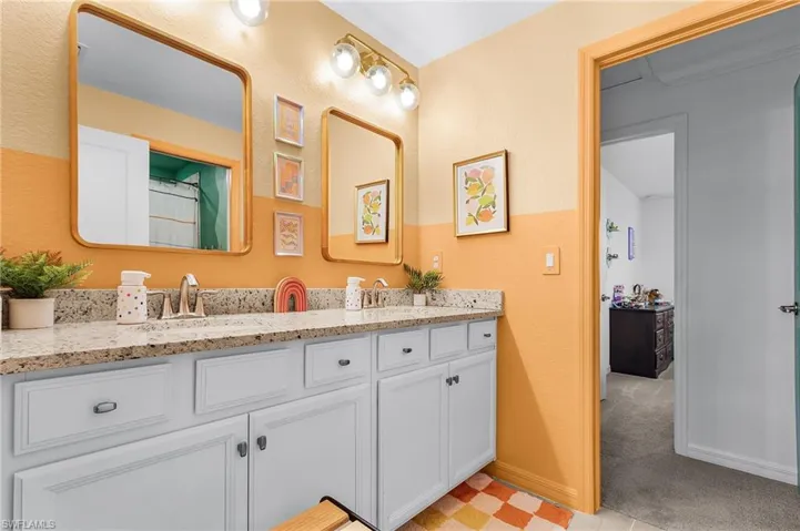Bathroom with double vanity and baseboards