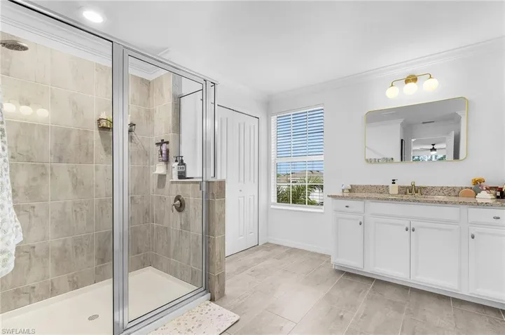 Bathroom with vanity, ornamental molding, a stall shower, and wood finish floors