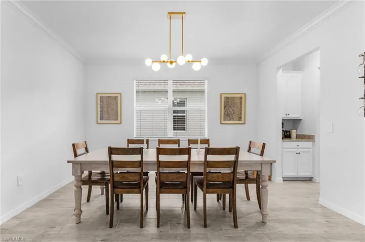 Dining area with crown molding and a chandelier