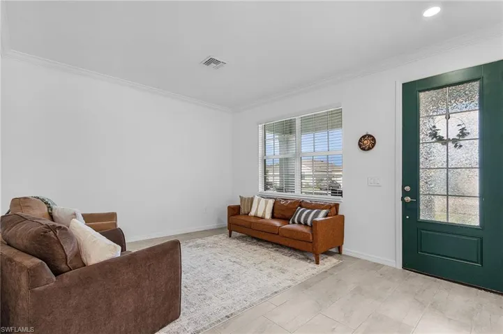 Living area featuring ornamental molding and baseboards