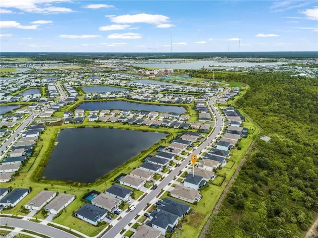 Aerial view of property and surrounding area with a nearby body of water and nearby suburban area